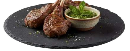 Lamb chops on a dark serving board with a green herb dip.
