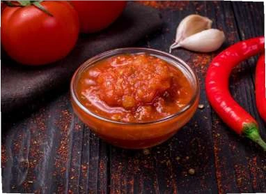 Salsa Roja in a glass bowl with tomatoes, chilli and garlic.